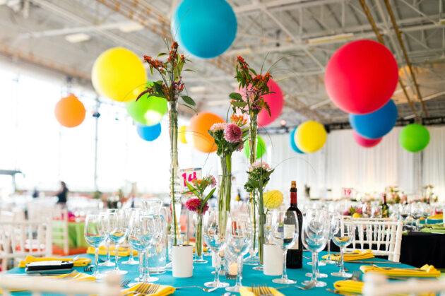 decorated tables with colored balls hanging above.