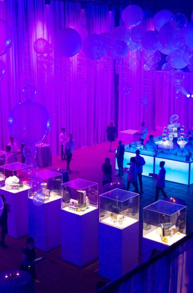 cases of auction items in a purple decorated room.