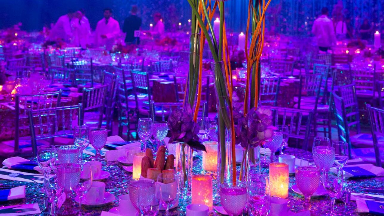 purple decorated tables with elaborate flower setting.