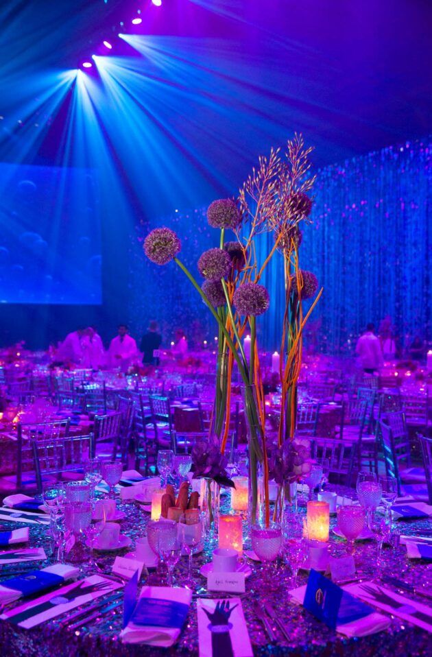 purple decorated tables with elaborate flower setting.