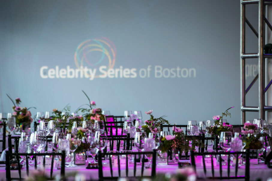 tables set in front of celebrity series of boston logo on wall.