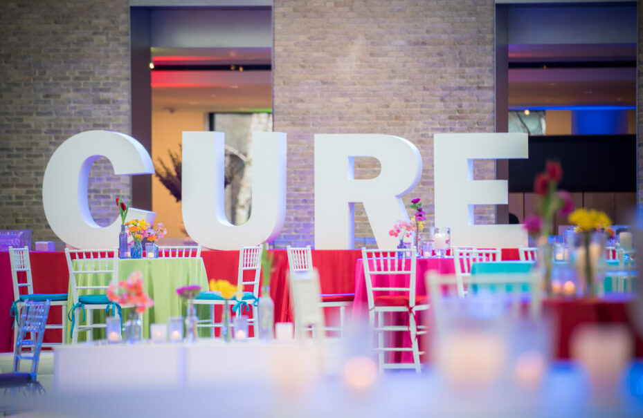 Large "cure" letters as a backdrop at a colorful event venue spaces setting.