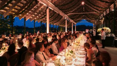 long table with people eating under a roof with no walls.