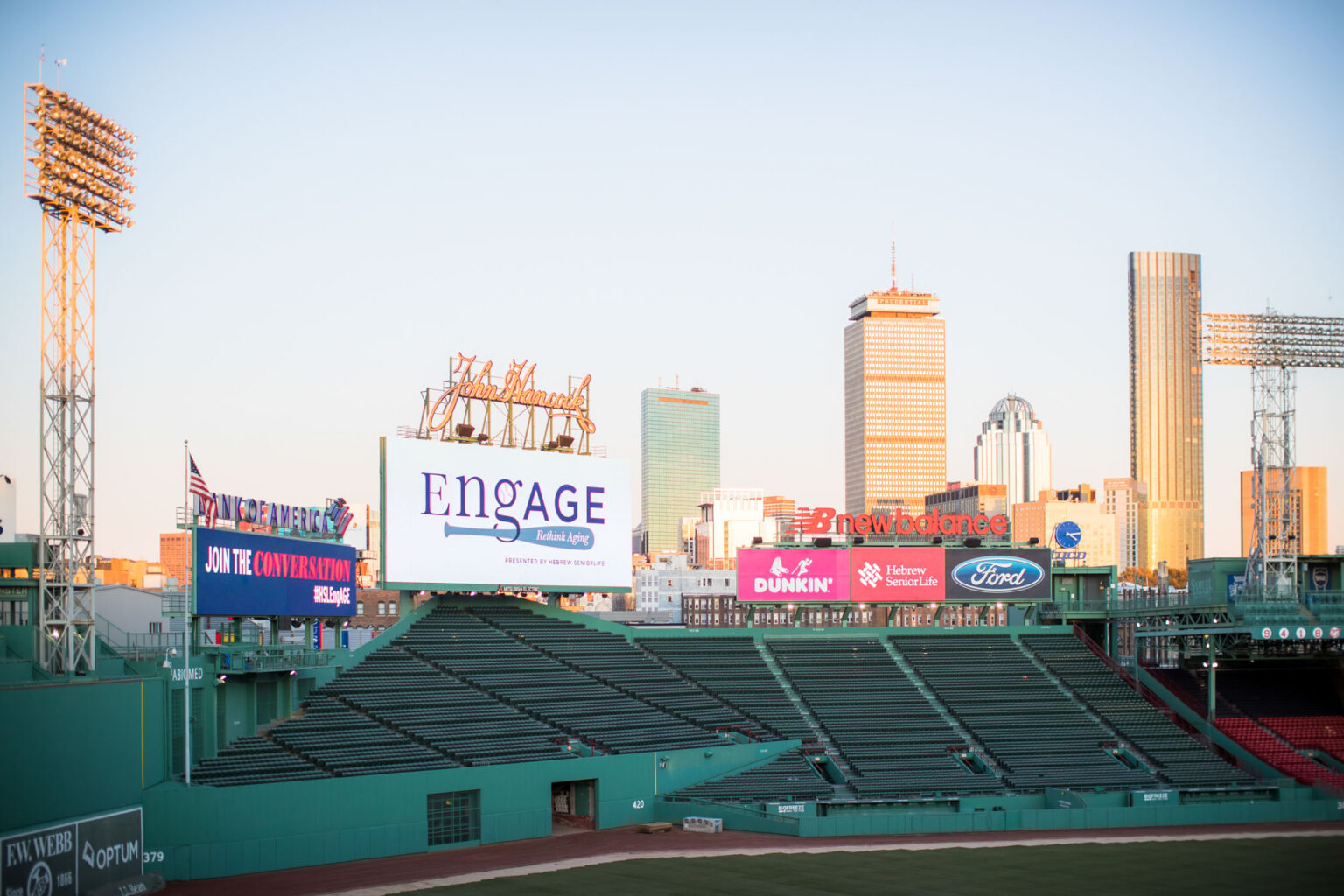 Empty baseball stadium, a prime event venue space, with a view of a distant city skyline during twilight.