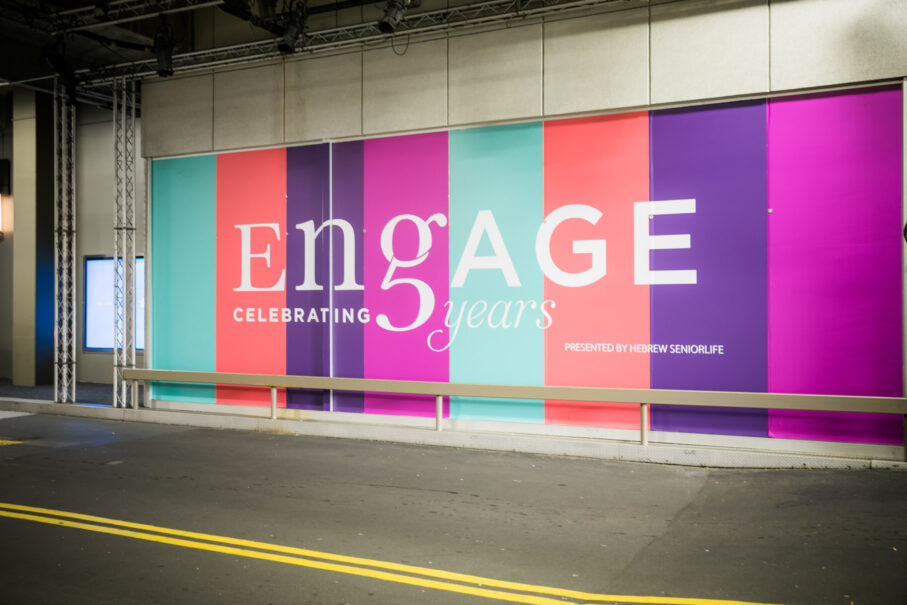 engage sign on wall next to street.