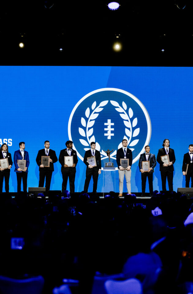 stage of men holding plaques in front of screen that says 2021 national scholar atheletes.