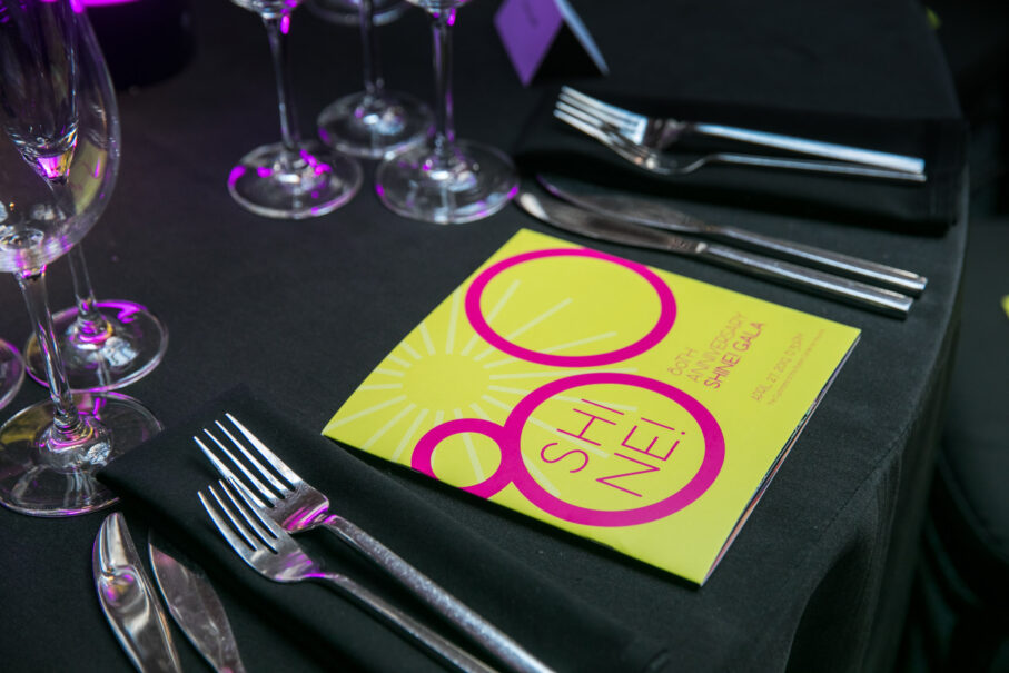 Elegant table setting with menu card for an event titled "Shine," expertly coordinated by a professional event planning company.