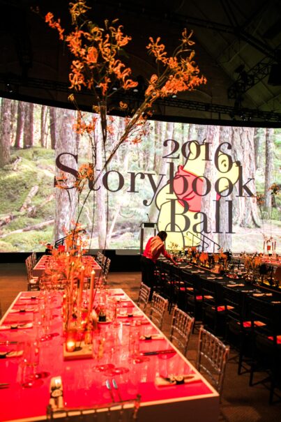 tables set in front of screen that says 2016 storybook ball.