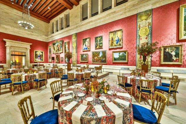 Elegant dining hall with tables set for a formal event, surrounded by ornate art and richly decorated walls, serving as an ideal event venue space.