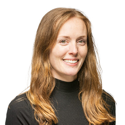 A smiling woman with long brown hair wearing a black turtleneck against a white background, representing an event planning company.