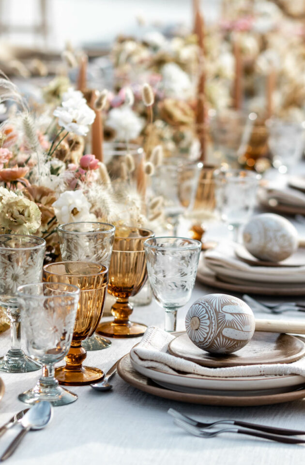 Elegant outdoor dining setup with natural-themed table decorations and place settings, organized by a top event planning company.