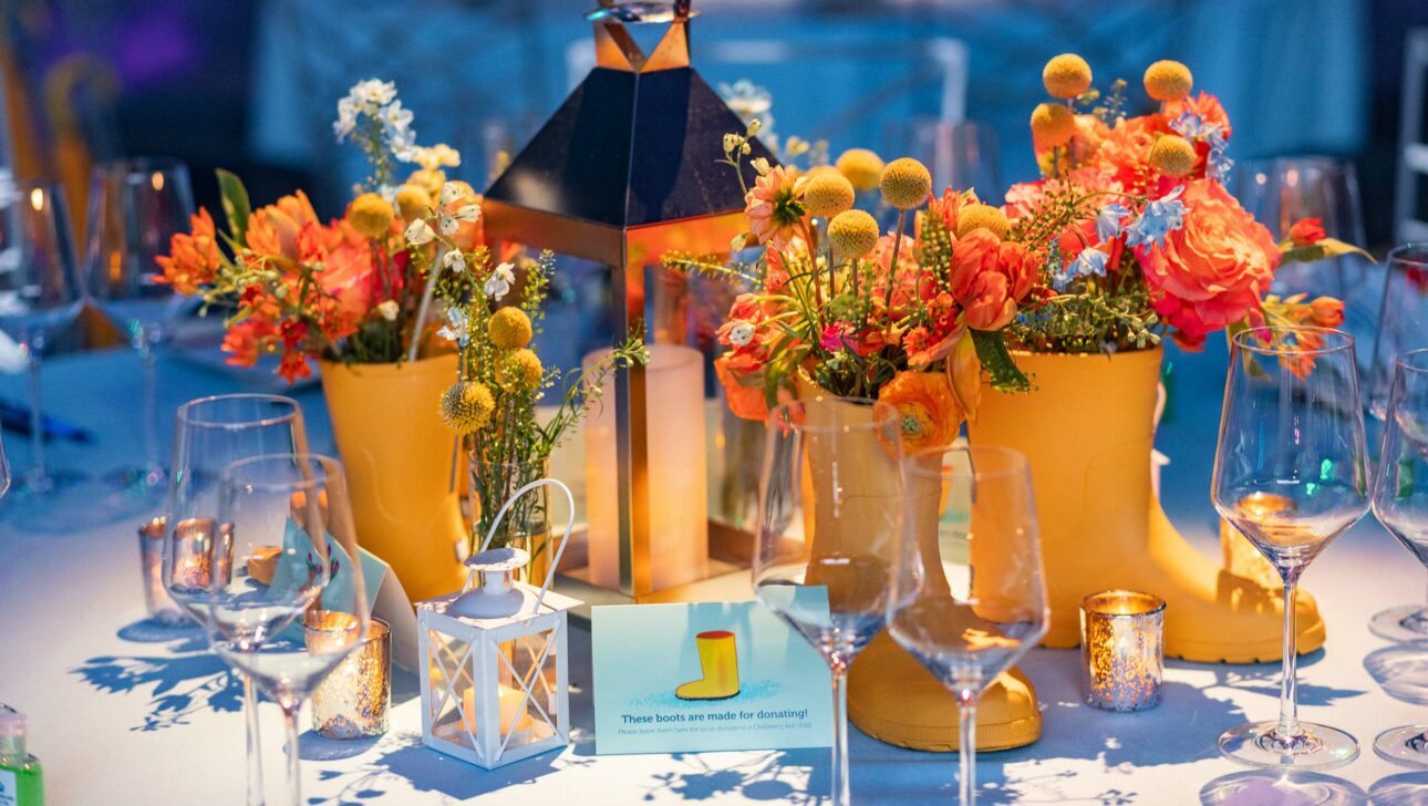 decorated table with flowers in yellow rainboots.