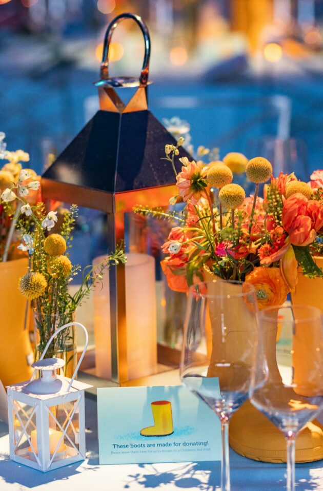 decorated table with flowers in yellow rainboots.