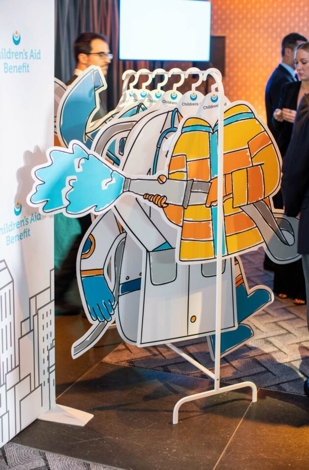 A cardboard cutout of a stylized elephant character provided by an event planning company at a children's aid benefit event.