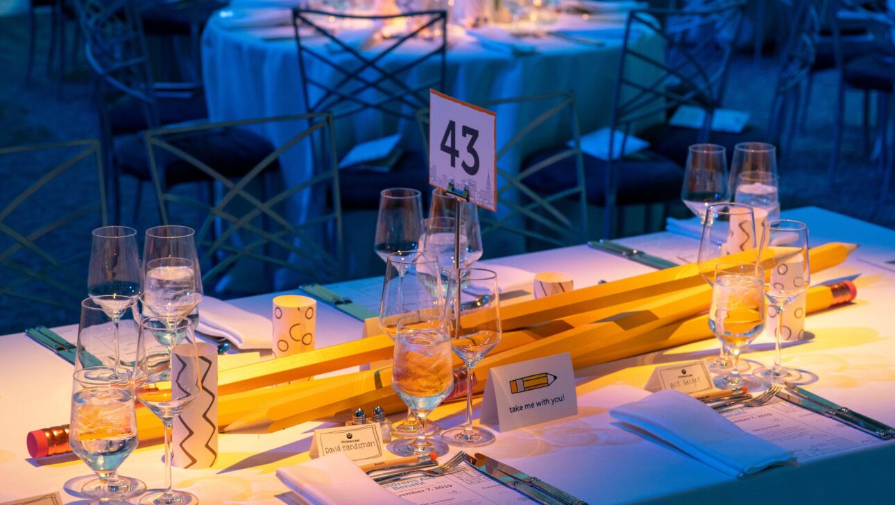 dining table decorated with yard long oversized pencils as a centerpiece.