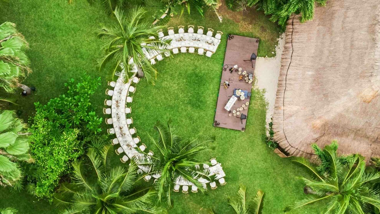 c shaped dining table under palm trees.