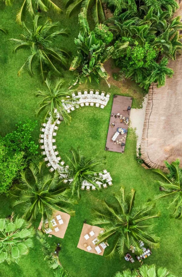c shaped dining table under palm trees.