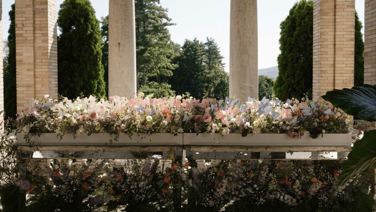 flower arrangements in front of stone columns.