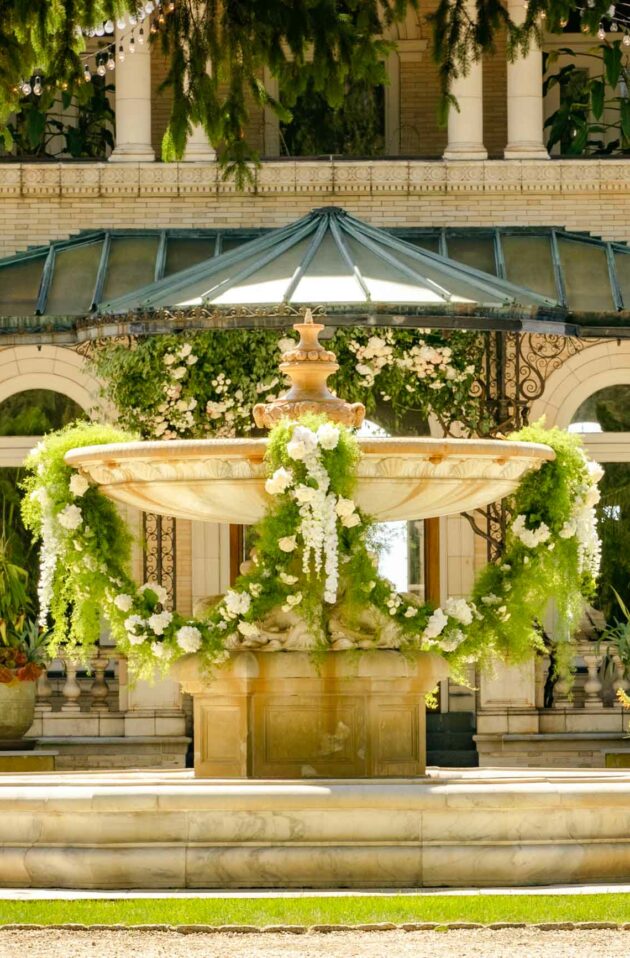 decorated fountain in front of an estate house.