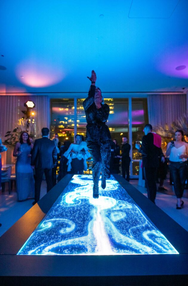 woman dancing on a videoboard table at a party.