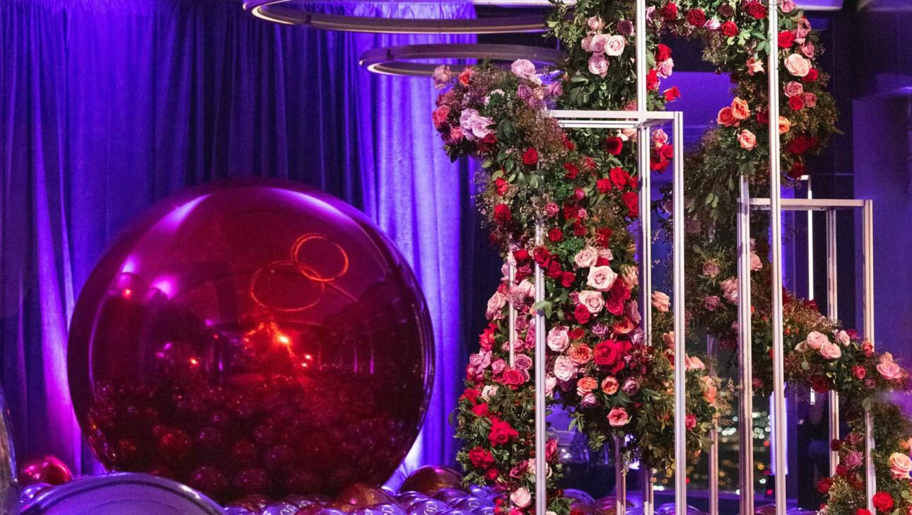 floral arrangements on metal stands in a purple and pink room.
