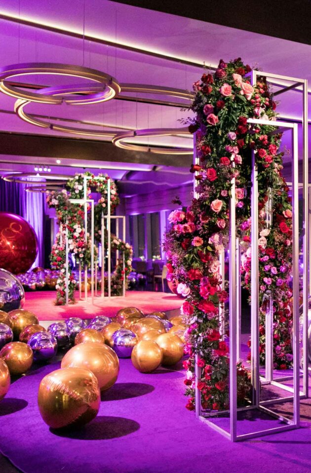 purple room filled with large colorful balls and floral arrangements.