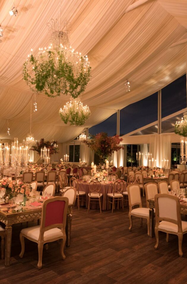 Elegant event venue space setup with chandeliers and floral arrangements.