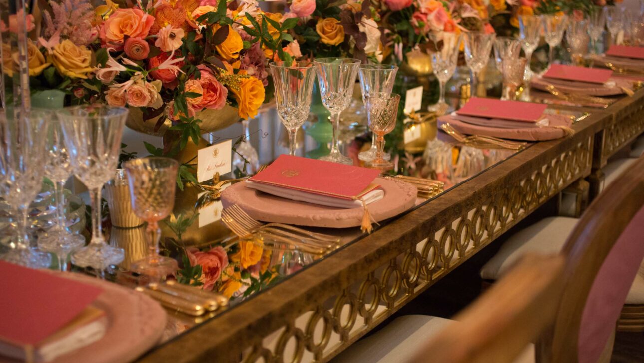 Elegant banquet table setting by an event planning company, featuring floral centerpieces and crystal glassware.