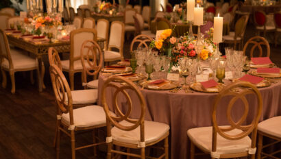 Elegant dining setup for a formal event organized by event planners, featuring floral centerpieces and candlelight.