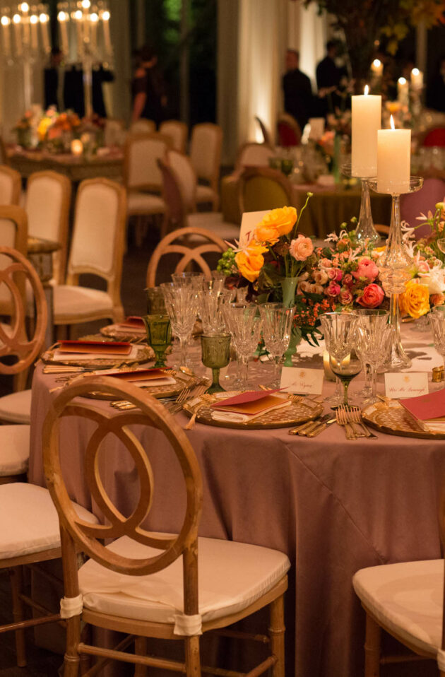 decorated dining tables with chairs and candle and floral centerpieces.