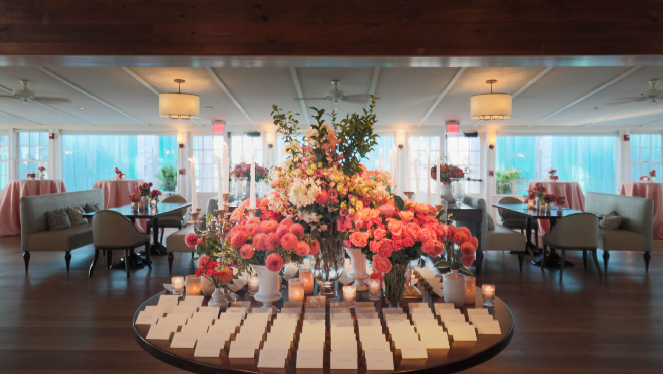 Elegant event venue space decorated with floral arrangements and candles.