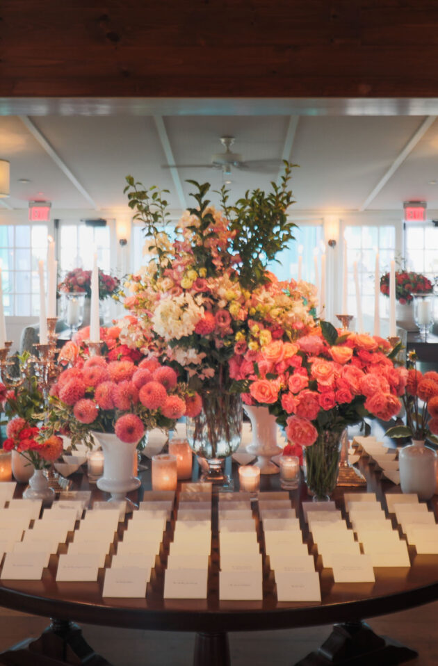 place cards on a table with floral arrangements behind.