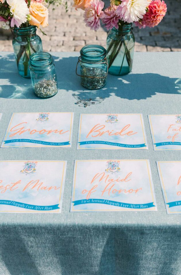 A table with neatly arranged wedding place cards alongside floral centerpieces, curated by an event planning company.