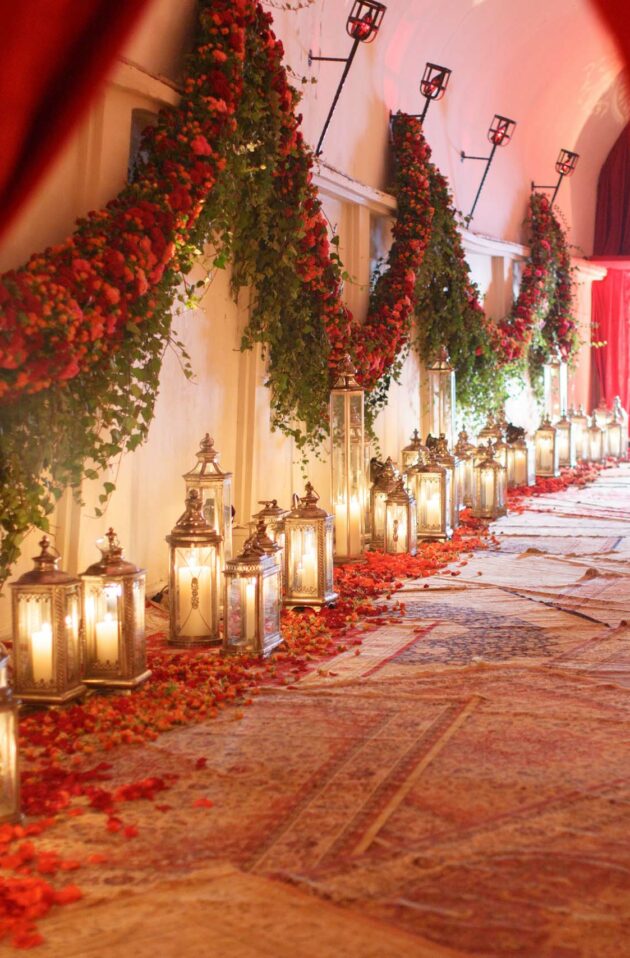 hallway covered in rugs lined with lamps and petals.