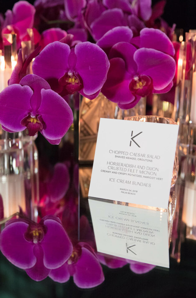 menu with a large k at a decorated place setting for a party.