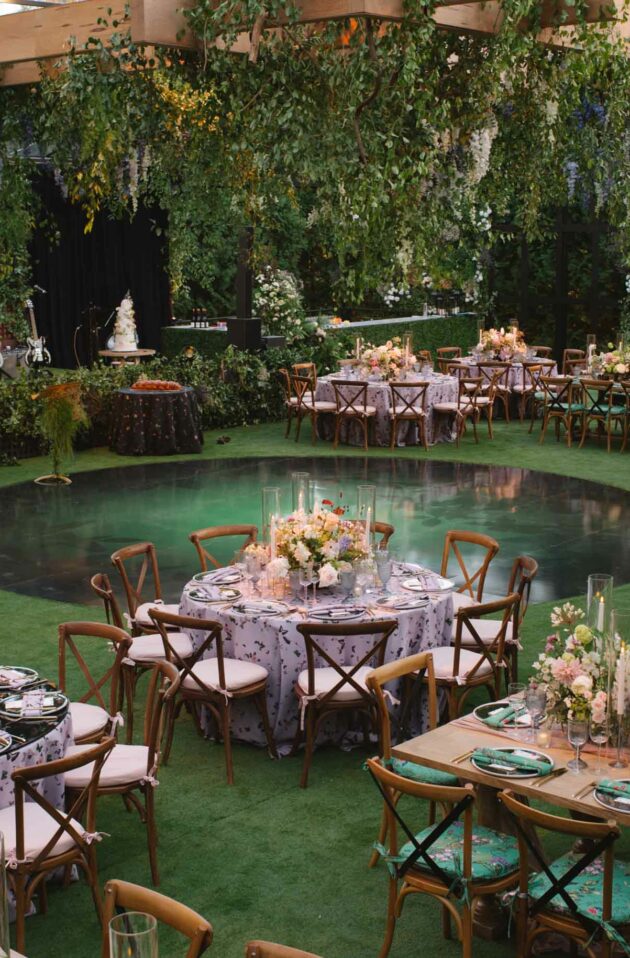 An elegantly arranged outdoor event venue space with floral decorations and set tables.