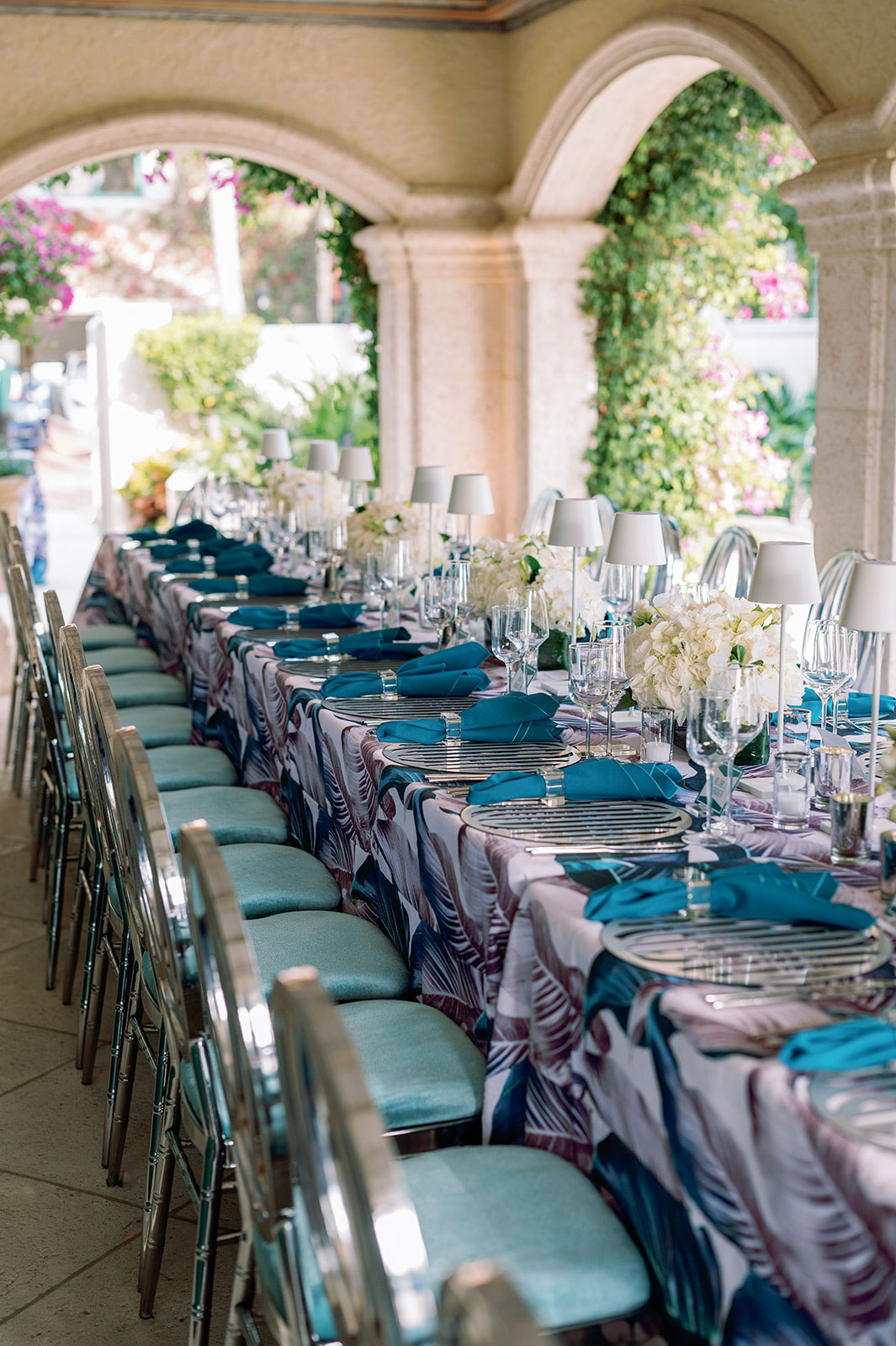 An elegantly set banquet table with blue tablecloths and floral decorations, prepared by a top event planning company for a formal event.