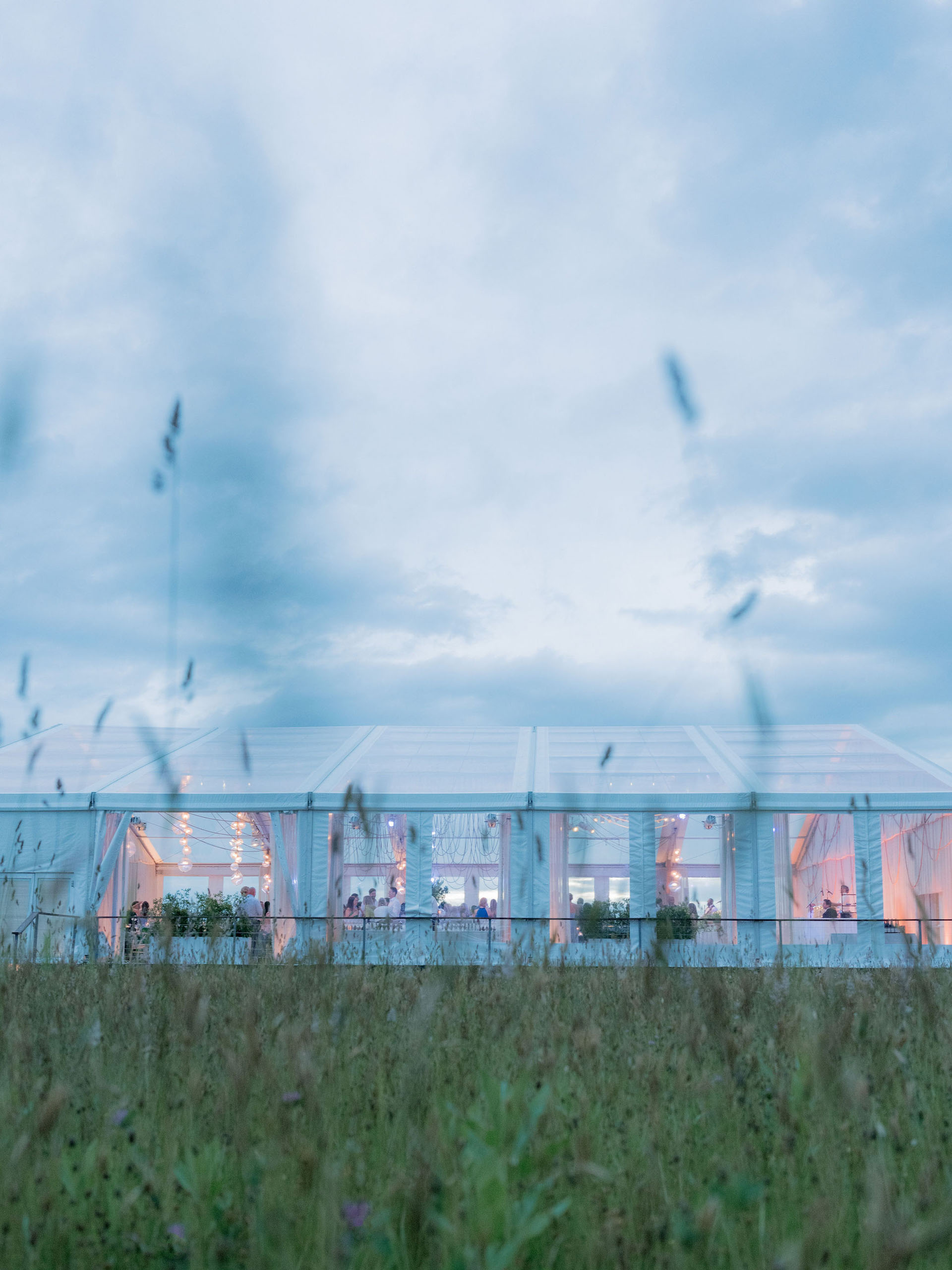 Elegant outdoor event venue space illuminated at dusk with a blue sky background.