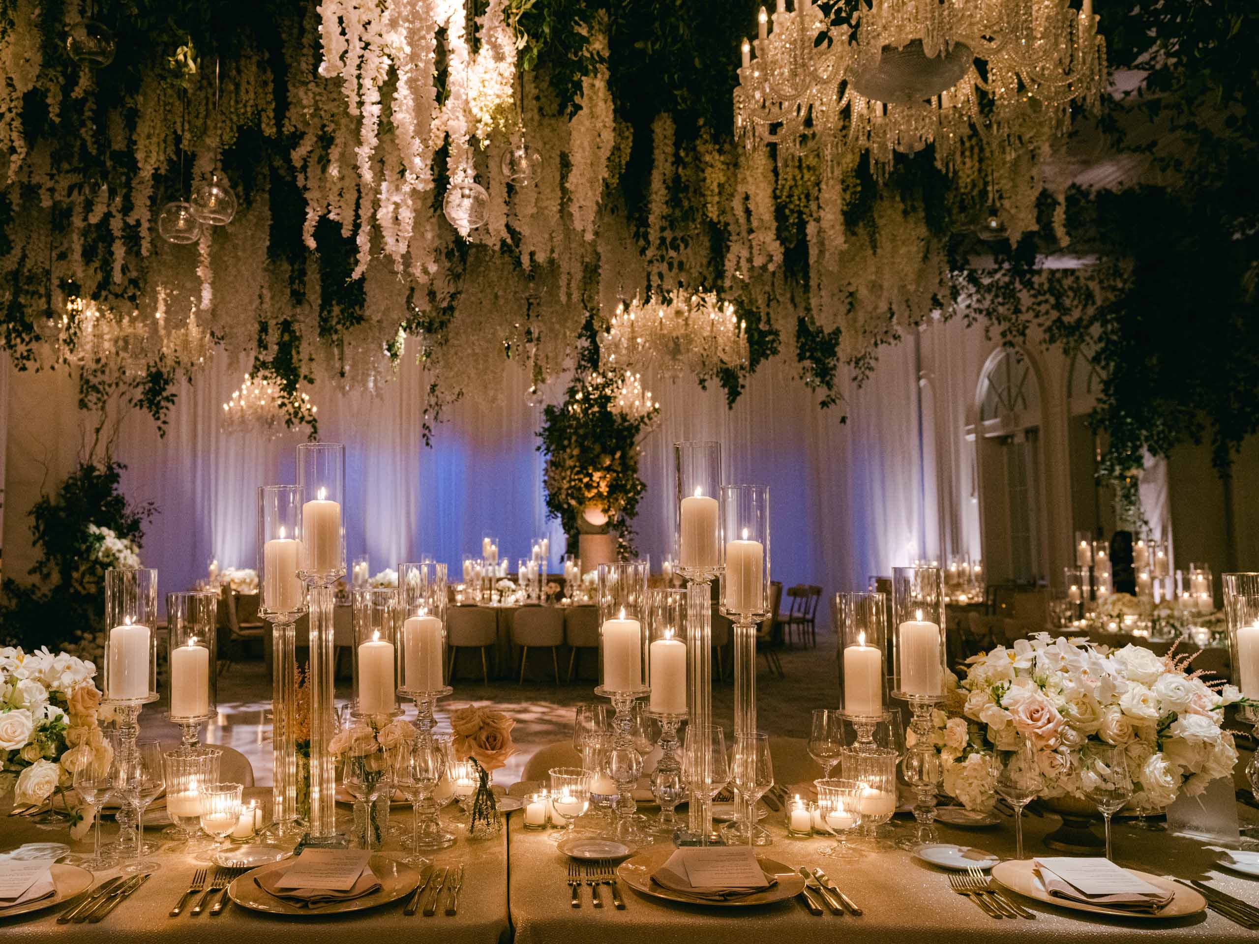 hall decorated for a wedding dinner with white floral arrangements.