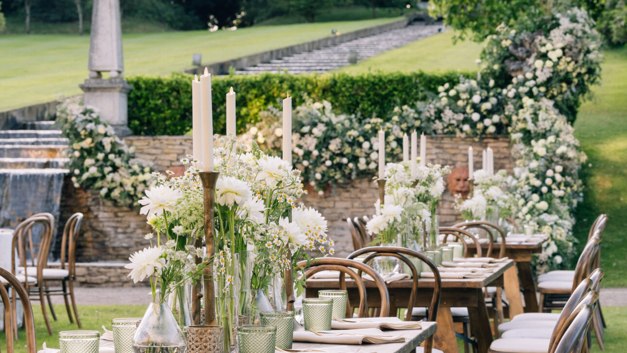 Wedding welcome dinner in beautiful outdoor garden with crisp white linens and white flowers. Designed by Rafanelli Events.