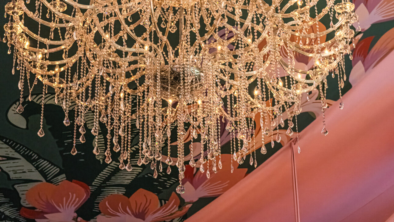 The exclusive amfAR Palm Beach Gala event seated gala dinner with stunning tent featuring custom fabric draped among crystal chandeliers. Event designed by Rafanelli Events.