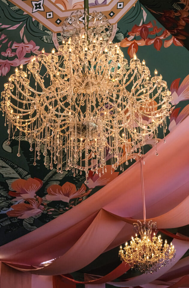 The exclusive amfAR Palm Beach Gala event seated gala dinner with stunning tent featuring custom fabric draped among crystal chandeliers. Event designed by Rafanelli Events.